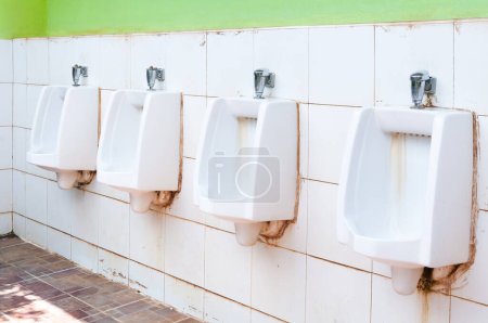 Photo for Line of white porcelain urinals in public toilets, dirty toilets outdoor - Royalty Free Image