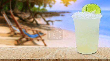 Photo for Cool freshly made lemonade in a plastic cups with crushed ice and lemon slices on wooden table with beach landscape nature background - Royalty Free Image