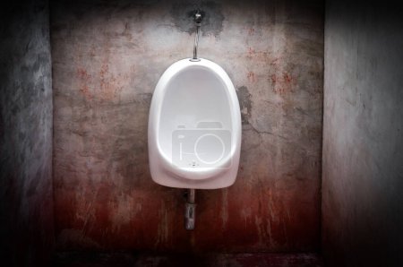 Photo for Urinal on old concrete red wall,scary toilet - Royalty Free Image