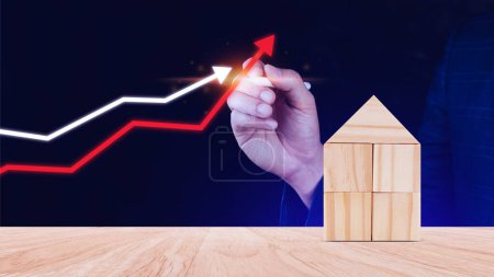 ein roter Pfeil und ein Holzhaus. Das Konzept der steigenden Immobilienpreise, der hohen Nachfrage nach Immobilien, des Anstiegs der Mietzinsen und der Hypothekenverkäufe von Wohnungen. Bevölkerung wächst.