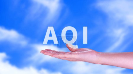 Foto de AQI, Abreviatura del índice de calidad del aire, mano que sostiene AQI en el fondo de la naturaleza, concepto del medio ambiente. - Imagen libre de derechos