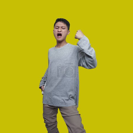 Téléchargez les photos : Jeune homme asiatique exprime joyeusement jusqu'à ce que ses mains sont levées - en image libre de droit