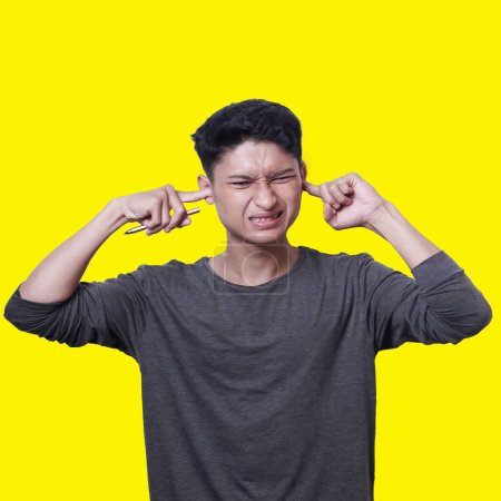 Photo for Young Asian man with an expression of being in pain wearing dark gray clothes - Royalty Free Image