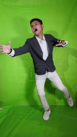Photo for The young Asian man with a look of pleasure and shock, as if he wanted to fly and fall - Royalty Free Image