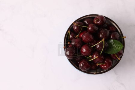 Téléchargez les photos : Bol de cerises fraîches savoureuses sur fond de marbre blanc. photo de haute qualité - en image libre de droit