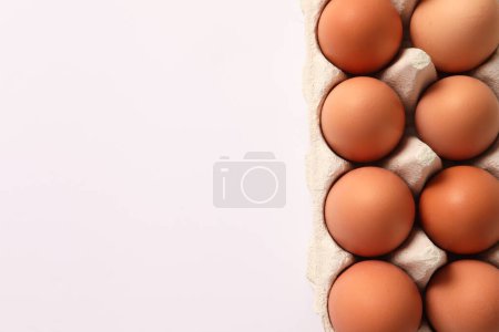 Photo for Top view of brown chicken eggs in carton on grey background - Royalty Free Image
