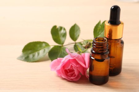 Téléchargez les photos : Bottle of oil and fresh flowers on a wooden background - en image libre de droit