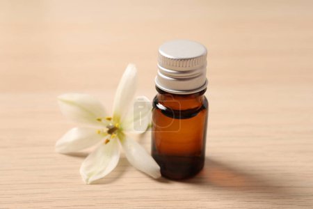 Téléchargez les photos : Essential essential oil in bottle on wooden background, close up - en image libre de droit