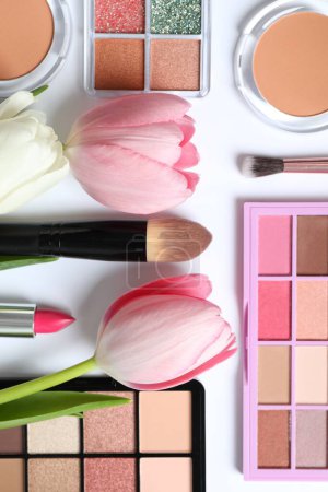 Téléchargez les photos : Ensemble de cosmétiques décoratifs avec des tulipes fraîches sur fond blanc - en image libre de droit