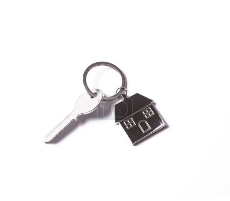 Metallic key with keychain in shape of house isolated on white background
