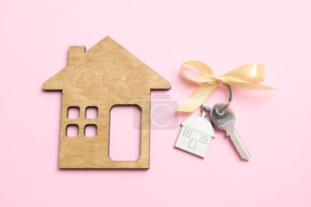 Téléchargez les photos : Clé métallique avec porte-clés et maison en bois sur fond couleur - en image libre de droit