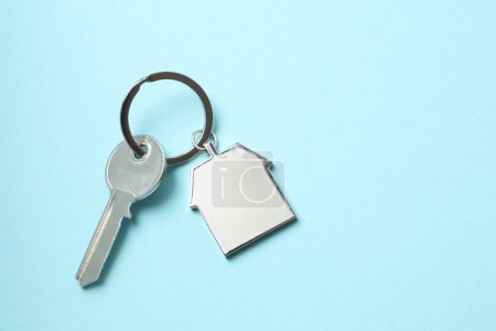 Téléchargez les photos : Clé métallique avec porte-clés en forme de maison sur fond de couleur - en image libre de droit