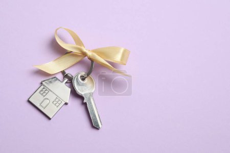 Téléchargez les photos : Clé métallique avec porte-clés en forme de maison sur fond de couleur - en image libre de droit