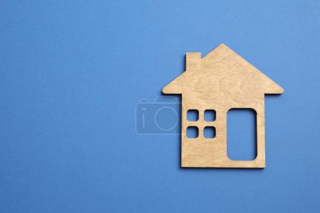 Wooden house on color background