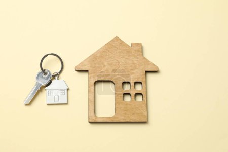 Téléchargez les photos : Clé métallique avec porte-clés et maison en bois sur fond couleur - en image libre de droit