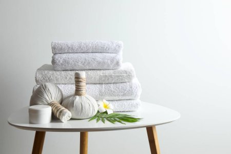 Serviettes blanches avec sacs de massage dans la chambre spa