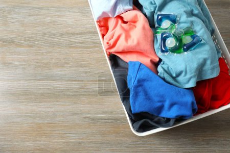 Capsules with liquid laundry detergent lie on clothes 