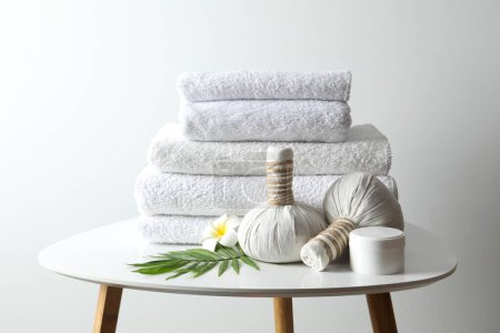 Serviettes blanches avec sacs de massage dans la chambre spa