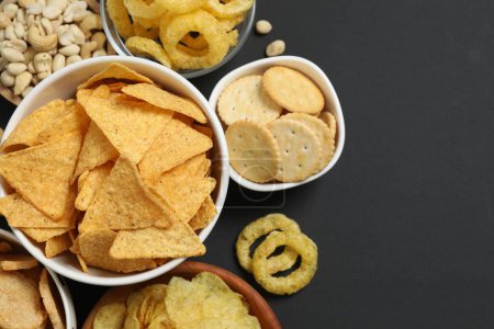 Verschiedene ungesunde Snacks auf schwarzem Hintergrund