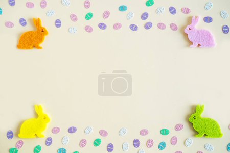 Foto de Colorful eggs confetti and rabbits on pastel background with copy space. Top view - Imagen libre de derechos