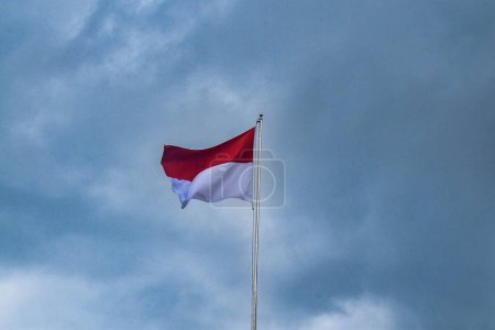 Téléchargez les photos : Drapeau indonésien flottant avec nuages arrière-plan - Symbole de fierté nationale et de sérénité - en image libre de droit