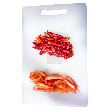 chopped Chili Pepper and Tomato on a cutting board, prepped fresh vegetables isolated on white background