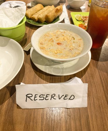 Reserved sign on table in restaurant with food served