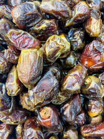 Full frame background top view of pile of appetizing dried date medjoul fruits displayed on market