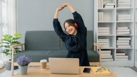 Téléchargez les photos : Jeune femme asiatique Relax étirement des bras après étude en ligne, après avoir travaillé. - en image libre de droit