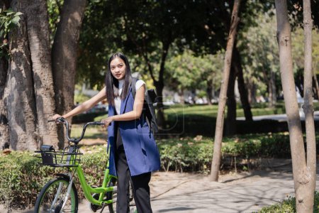 Berufstätige Geschäftsfrau mit Fahrrad morgens zu Fuß auf der Straße zur Arbeit. Umweltfreundlich.