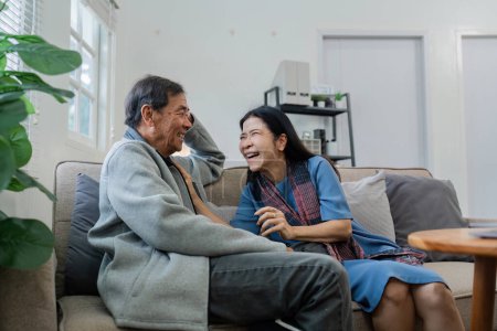 Las parejas mayores se sientan y charlan y se dirigen el uno al otro relajados y felices en el sofá en casa durante la semana en un cómodo.