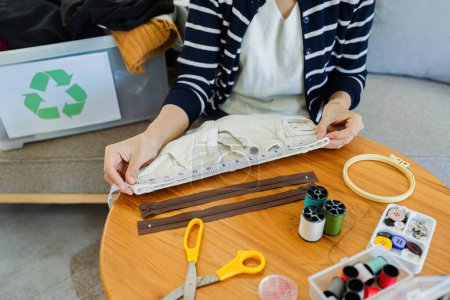 Mujer asiática reparar pantalón viejo para reciclar ropa vieja. Concepto de ropa de reciclaje.
