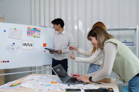 Diseñadores de interfaz de usuario presentan al equipo sobre el diseño de color del logotipo durante la lluvia de ideas de diseño de aplicaciones. Agencia creativa de desarrollo digital. Concepto UX UI.