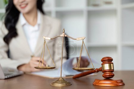 A professional lawyer working at a desk with scales of justice and a gavel, symbolizing legal expertise and justice.