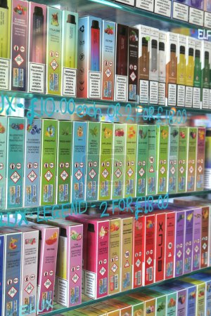 Téléchargez les photos : Leeds, Royaume-Uni - 09 09 2023 : Gros plan sur les cigarettes électroniques exposées dans la vitrine. L'Association des gouvernements locaux du Royaume-Uni a publié une déclaration en juillet 2023 appelant le gouvernement à interdire les cassettes jetables d'ici 2024. - en image libre de droit