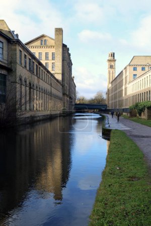 Téléchargez les photos : Saltaire, UK : 12 13 2023 - Relections of the Salts Mill complex along the Leeds Liverpool Canal. - en image libre de droit