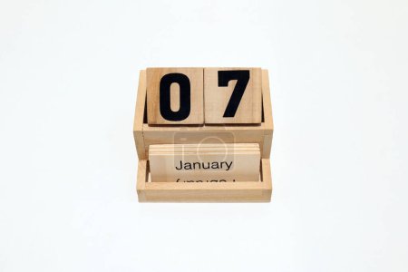 Close up of a wooden perpetual calendar showing the 7th of January. Shot close up isolated on a white background 
