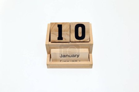 Nahaufnahme eines hölzernen ewigen Kalenders, der den 10. Januar zeigt. Nahaufnahme isoliert auf weißem Hintergrund 