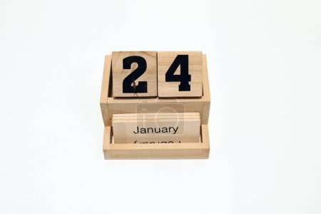 Gros plan d'un calendrier perpétuel en bois montrant le 24 janvier. Plan rapproché isolé sur fond blanc 