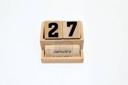 Gros plan d'un calendrier perpétuel en bois montrant le 27 janvier. Plan rapproché isolé sur fond blanc 
