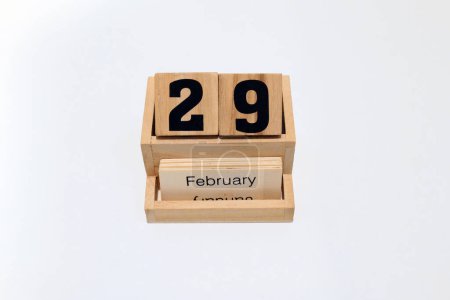 Foto de Primer plano de un calendario perpetuo de madera que muestra un año bisiesto, 29 de febrero. Disparo de cerca aislado sobre un fondo blanco - Imagen libre de derechos