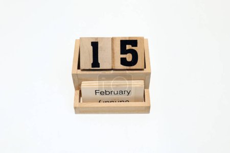 Close up of a wooden perpetual calendar showing the 15th of February. Shot close up isolated on a white background 