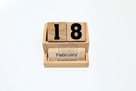 Close up of a wooden perpetual calendar showing the 18th of February. Shot close up isolated on a white background 