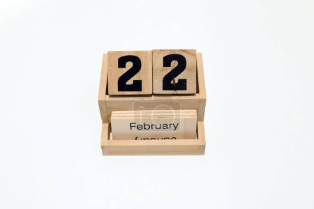 Close up of a wooden perpetual calendar showing the 22nd of February. Shot close up isolated on a white background 