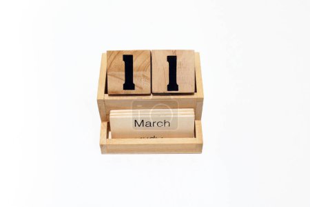Close up of a wooden perpetual calendar showing the 11th of March. Shot close up isolated on a white background