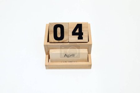 Close up of a wooden perpetual calendar showing the 4th of April. Shot close up isolated on a white background