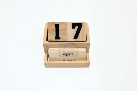 Close up of a wooden perpetual calendar showing the 17th of April. Shot close up isolated on a white background