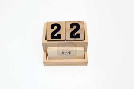 Close up of a wooden perpetual calendar showing the 22nd of April. Shot close up isolated on a white background