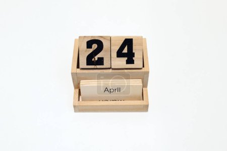 Close up of a wooden perpetual calendar showing the 24th of April. Shot close up isolated on a white background