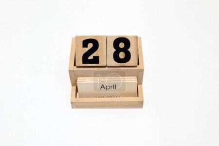 Photo for Close up of a wooden perpetual calendar showing the 28th of April. Shot close up isolated on a white background - Royalty Free Image